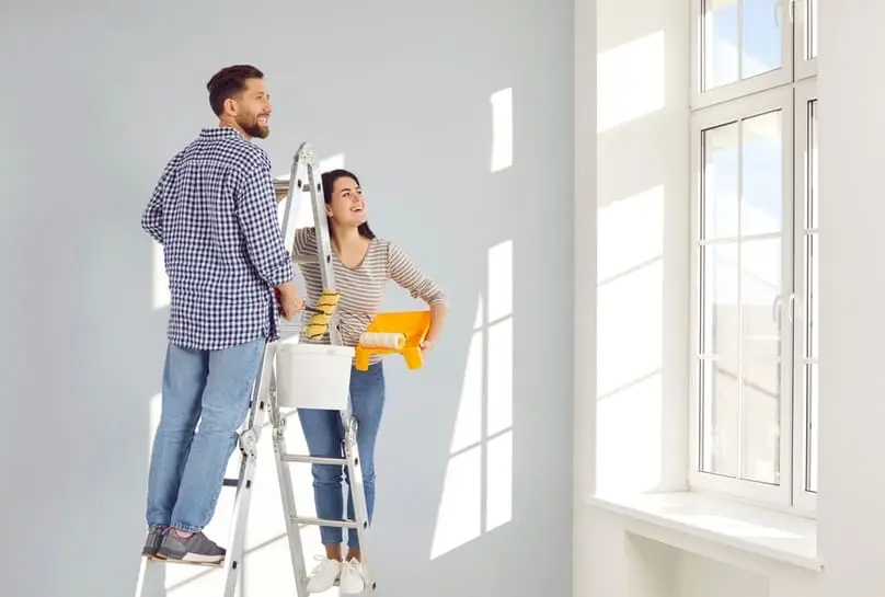 A contractor and woman in a kitchen, discussing details related to how to clean construction dust.
