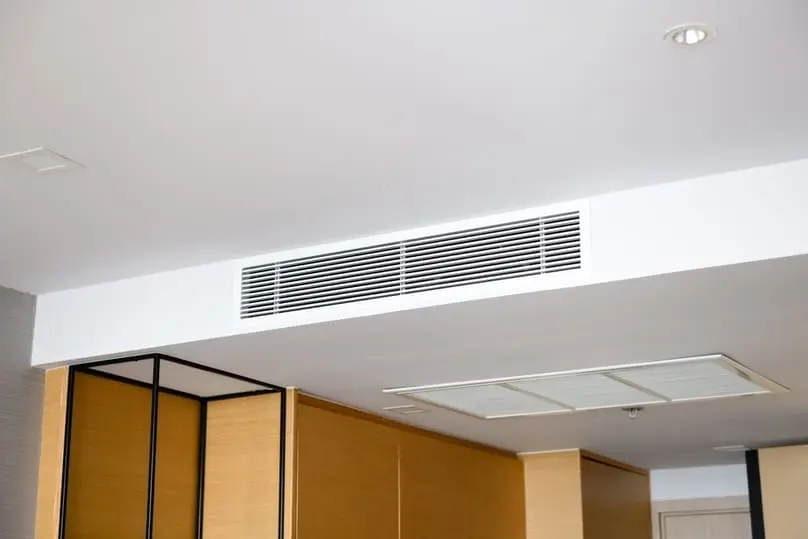 A rectangular air conditioning vent in a white ceiling, relevant to air duct cleaning methods.