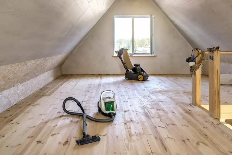 clean wooden attic floor with a vacuum and polisher, showing the best way to clean floors after construction.
