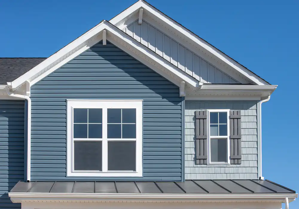Blue and gray home exterior with shutters, perfect for cleaning vinyl siding projects.