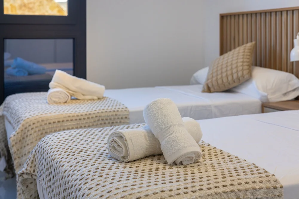 Fresh linens and folded towels prepared for an Airbnb guest bedroom