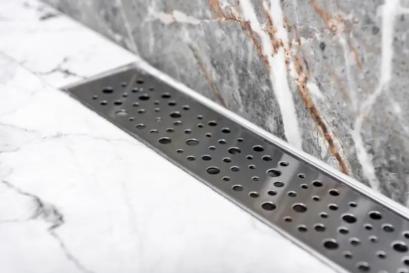 Clean linear shower drain on a marble bathroom floor