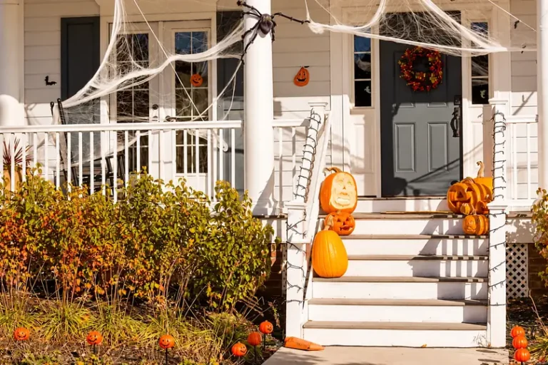 A front porch decorated with pumpkins and fake spider webs shares halloween cleaning ideas.